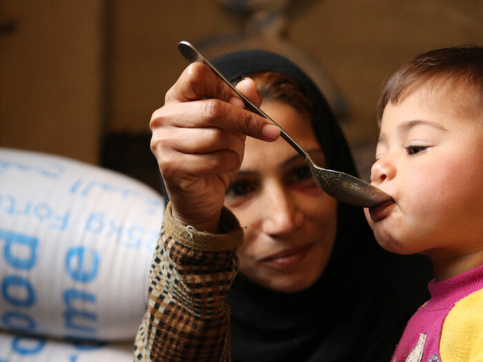مادر سوریه ای به کودک خود غذا می دهد